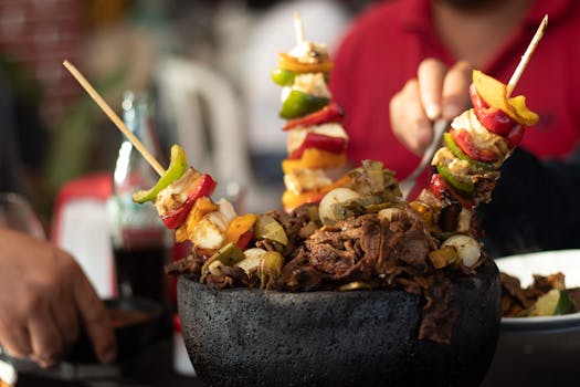 A mouthwatering close-up of grilled skewers with beef, vegetables, and cheese served in a rustic bowl.