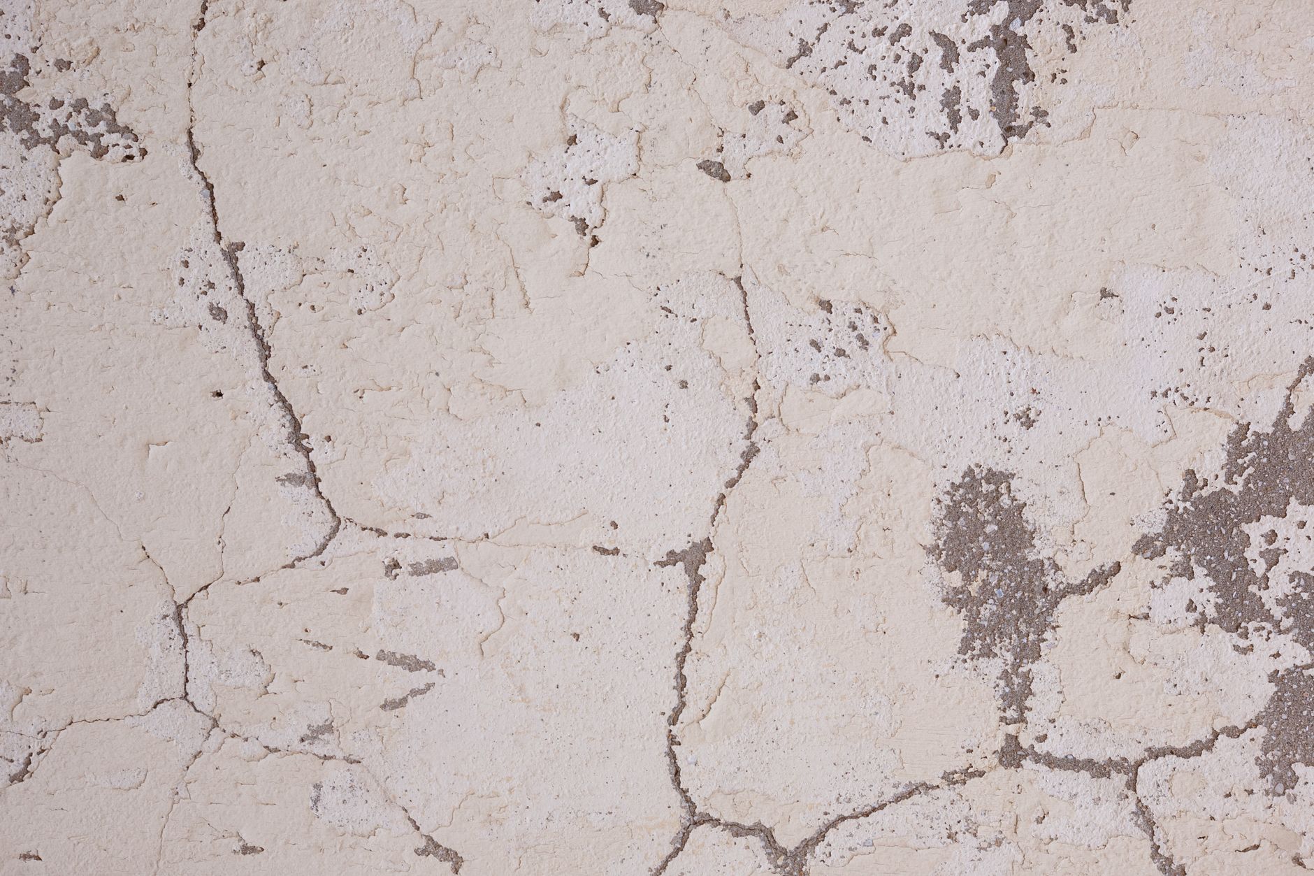 Close-up of cracked, damaged plaster on an interior wall, the kind of change a buyer may spot during a final walkthrough