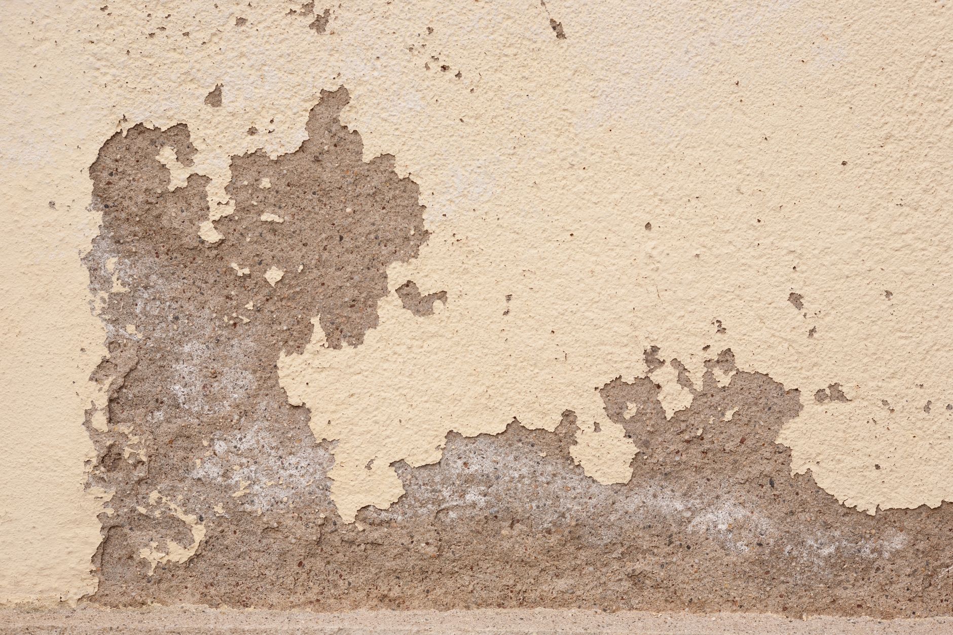 Old wall with cracked plaster showing rough textures, ideal for backgrounds.