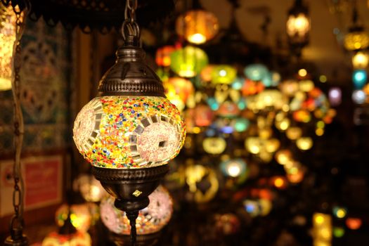 Vibrant, close-up view of mosaic lanterns, highlighting intricate designs in a glowing atmosphere.