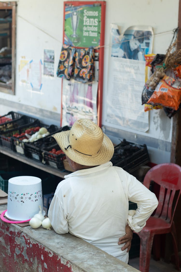 Man In Hat Selling On Outdoor Market