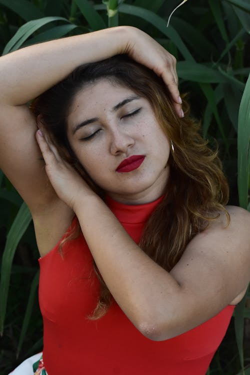 Close-up of Young Woman Posing on Green Plant Background