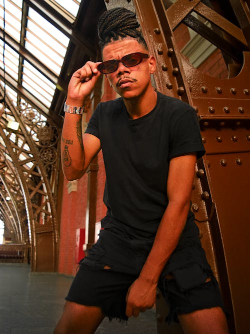 Man in a Black Shirt Posing with His Sunglasses