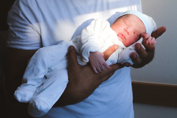 A Person Carrying A Baby