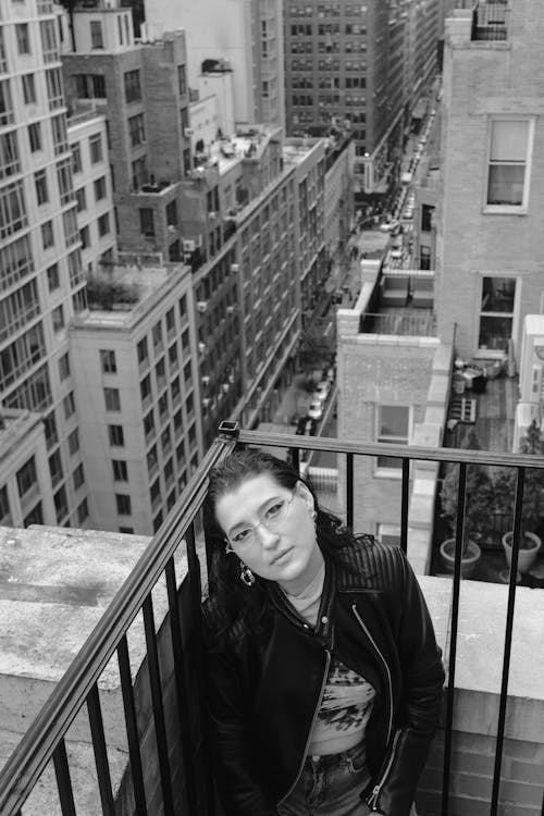 Free Grayscale Photo of a Woman Leaning on Railings Stock Photo