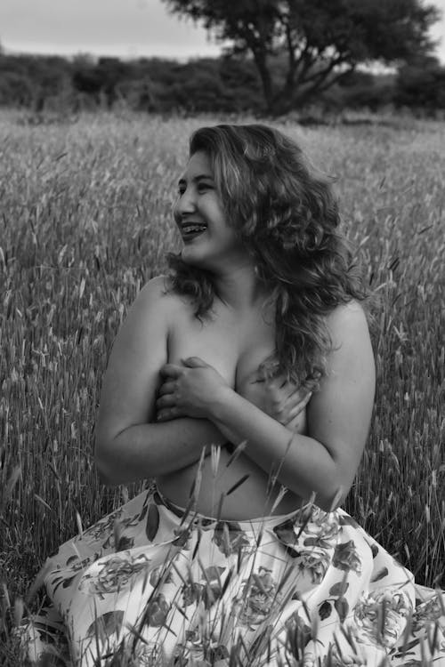 Grayscale Photograph of a Topless Woman Smiling