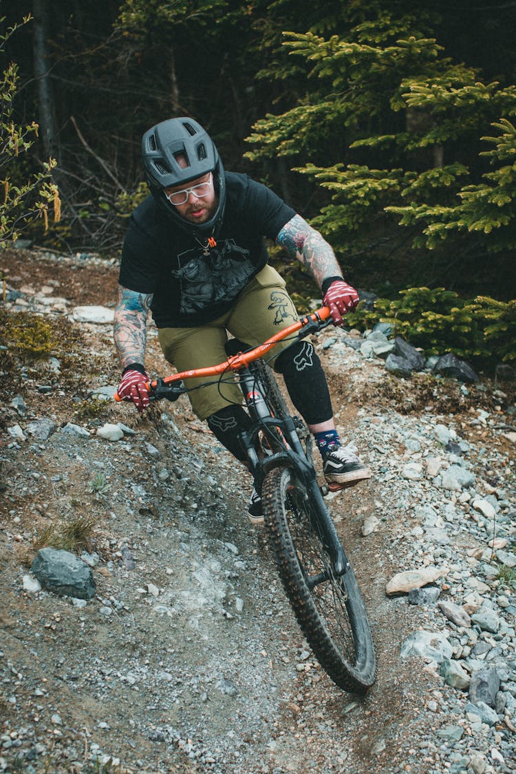 A Man Riding A Bike In The Forest