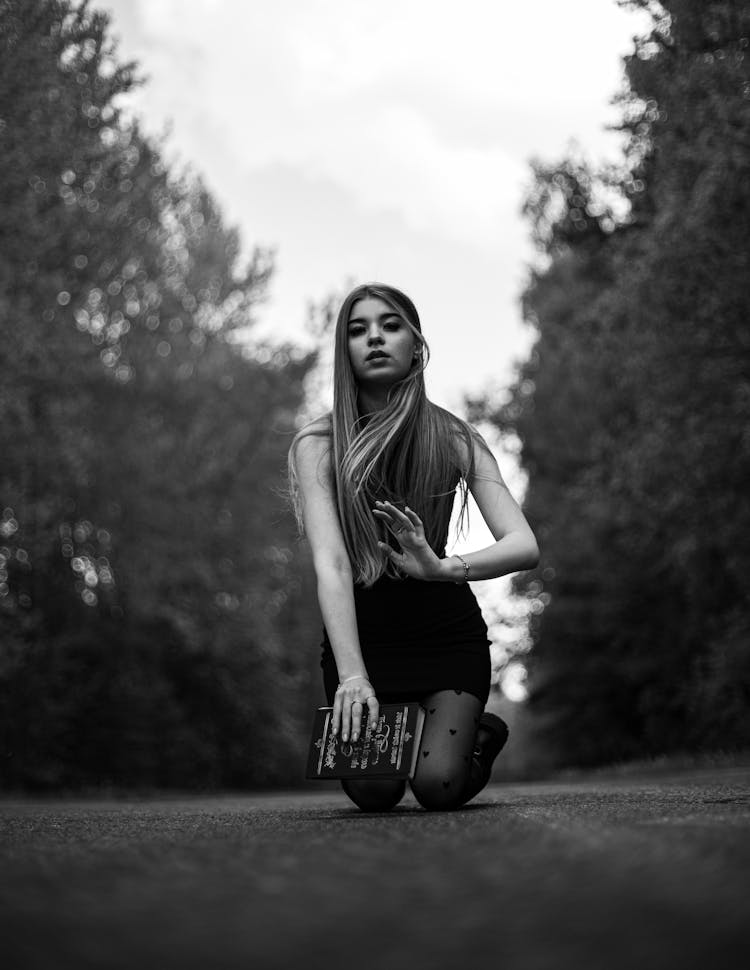 A Woman Kneeling On The Road 