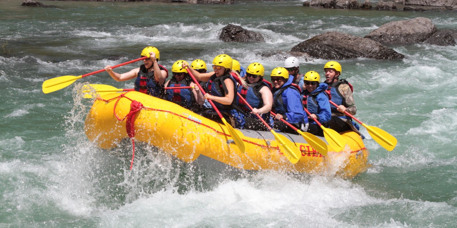 A rafting team working together to navigate powerful rapids