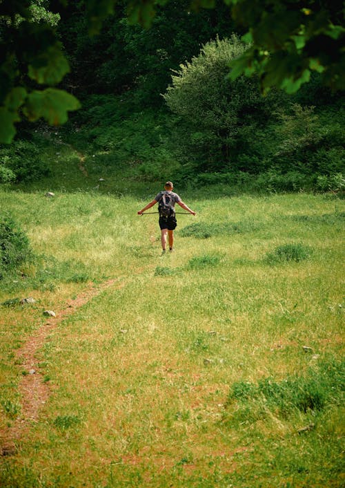 A Person Walking on a Grassy Field