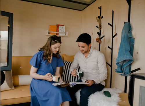 Free A couple enjoys coffee together while looking at magazines in a cozy indoor setting. Stock Photo