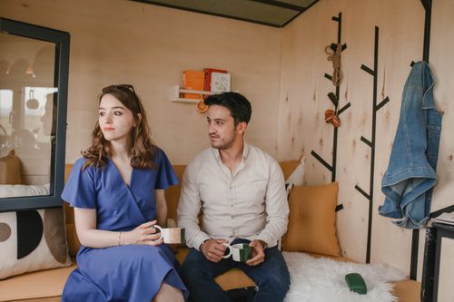 Free A couple enjoying coffee together in a stylish, cozy indoor space with warm decor. Stock Photo