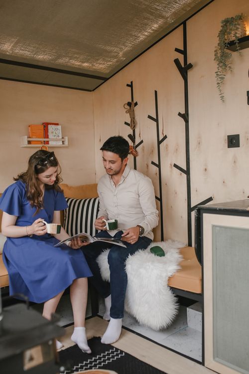 Free A couple enjoys reading together in a cozy modern room with stylish decor. Stock Photo