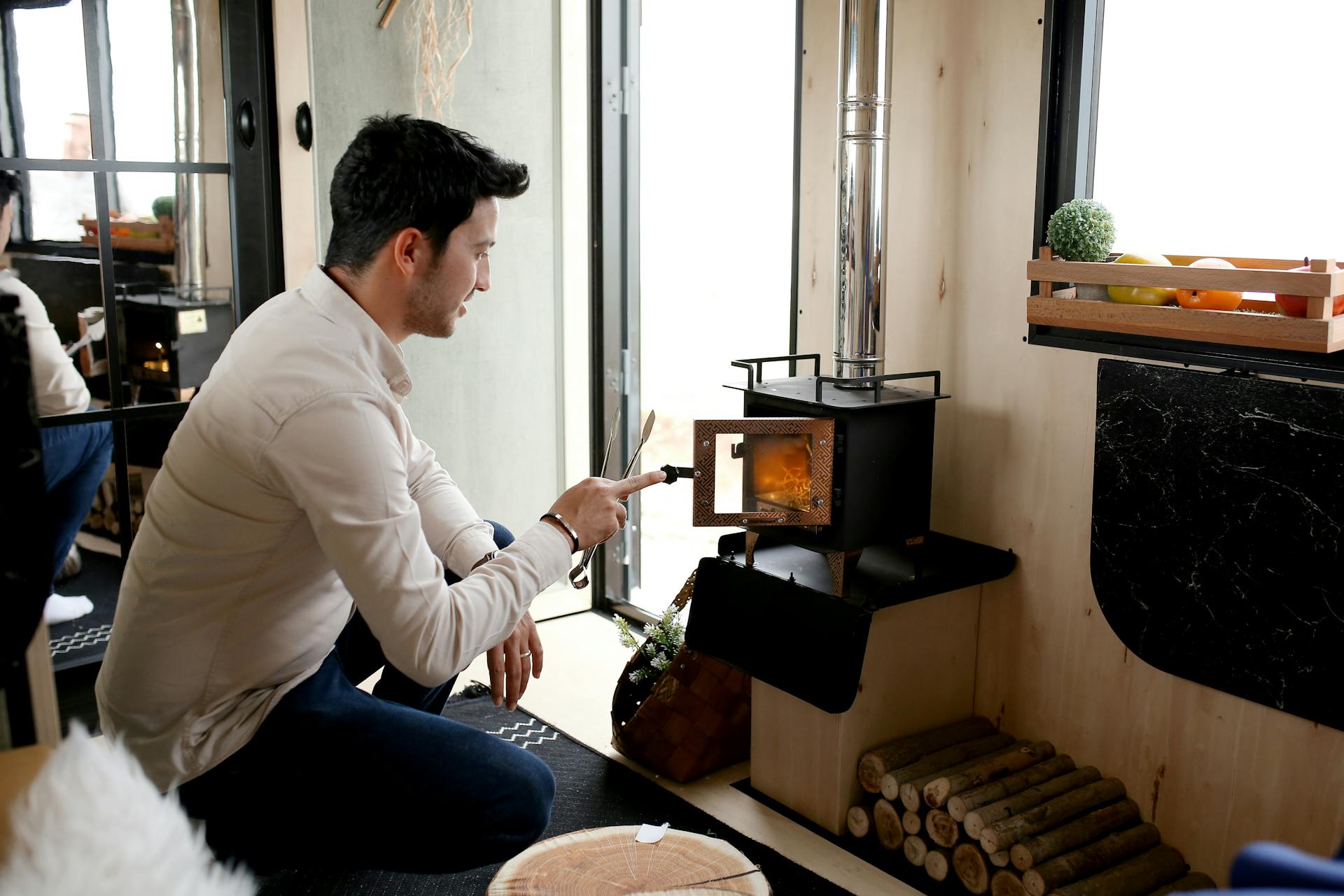 Man Burning Wood in Stove in Room