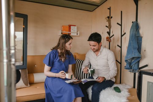 Free A young couple enjoys coffee and reading magazines together in a cozy indoor setting. Stock Photo