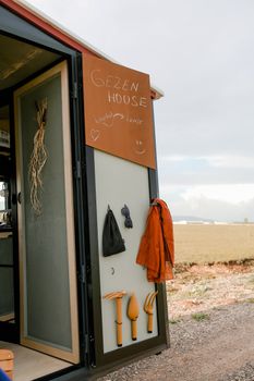 Entrance to a mobile home with a travel-themed sign and outdoor gear.