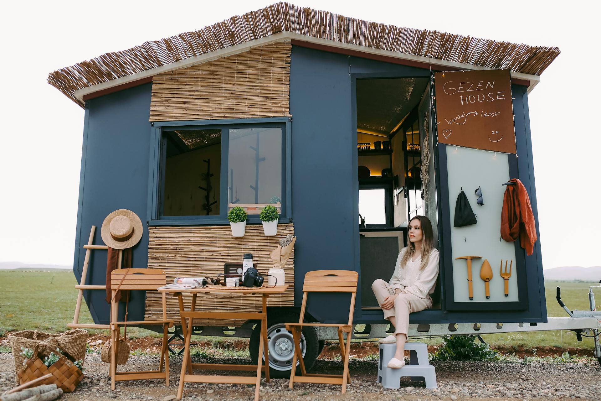 Woman Sitting in a Trailer Converted to a House on Wheels