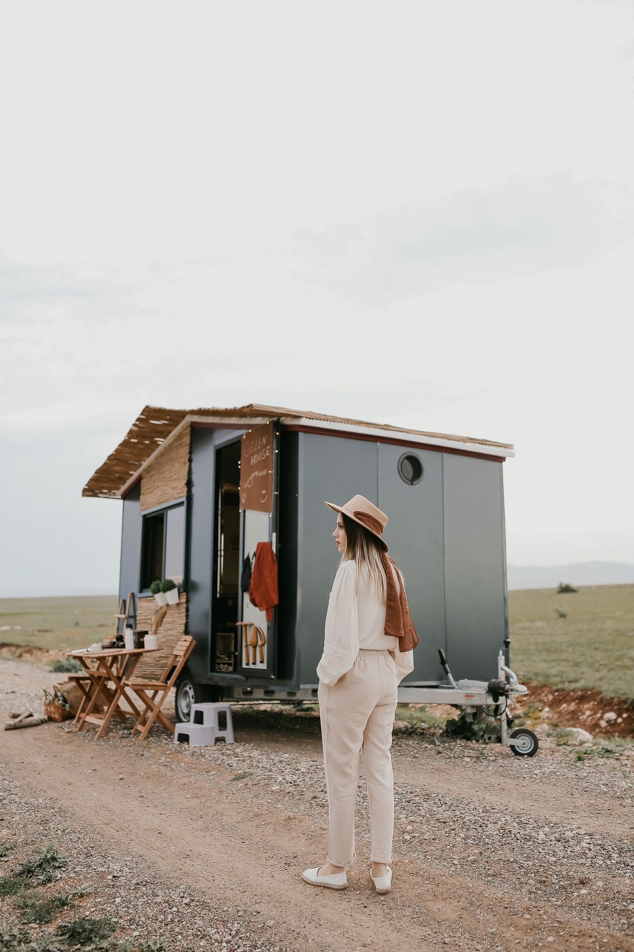 Woman standing beside a tiny house on wheels
