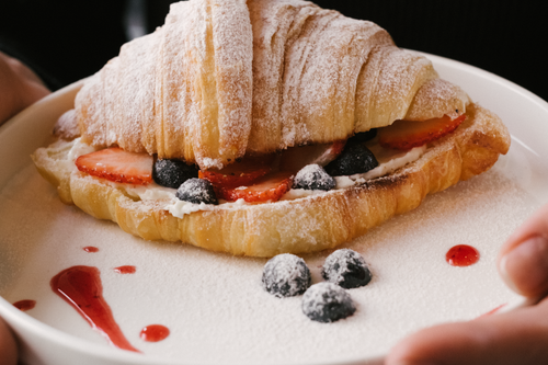 Free A mouthwatering croissant filled with cream and fresh berries, dusted with powdered sugar. Stock Photo