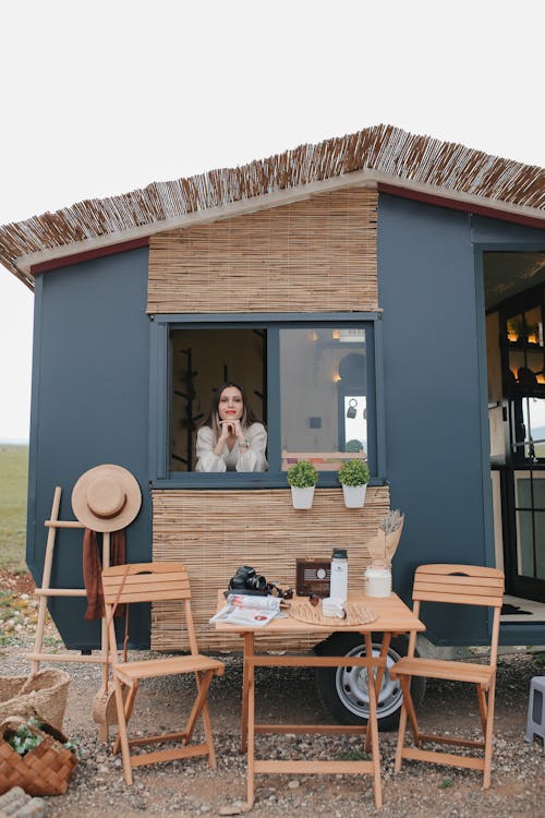 Woman Standing in a Trailer Converted to a House on Wheels