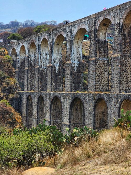 Free Majestic stone aqueduct spans an arid valley, showcasing ancient engineering. Stock Photo