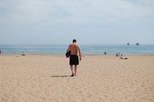 Foto profissional grátis de à beira-mar, andando, areia