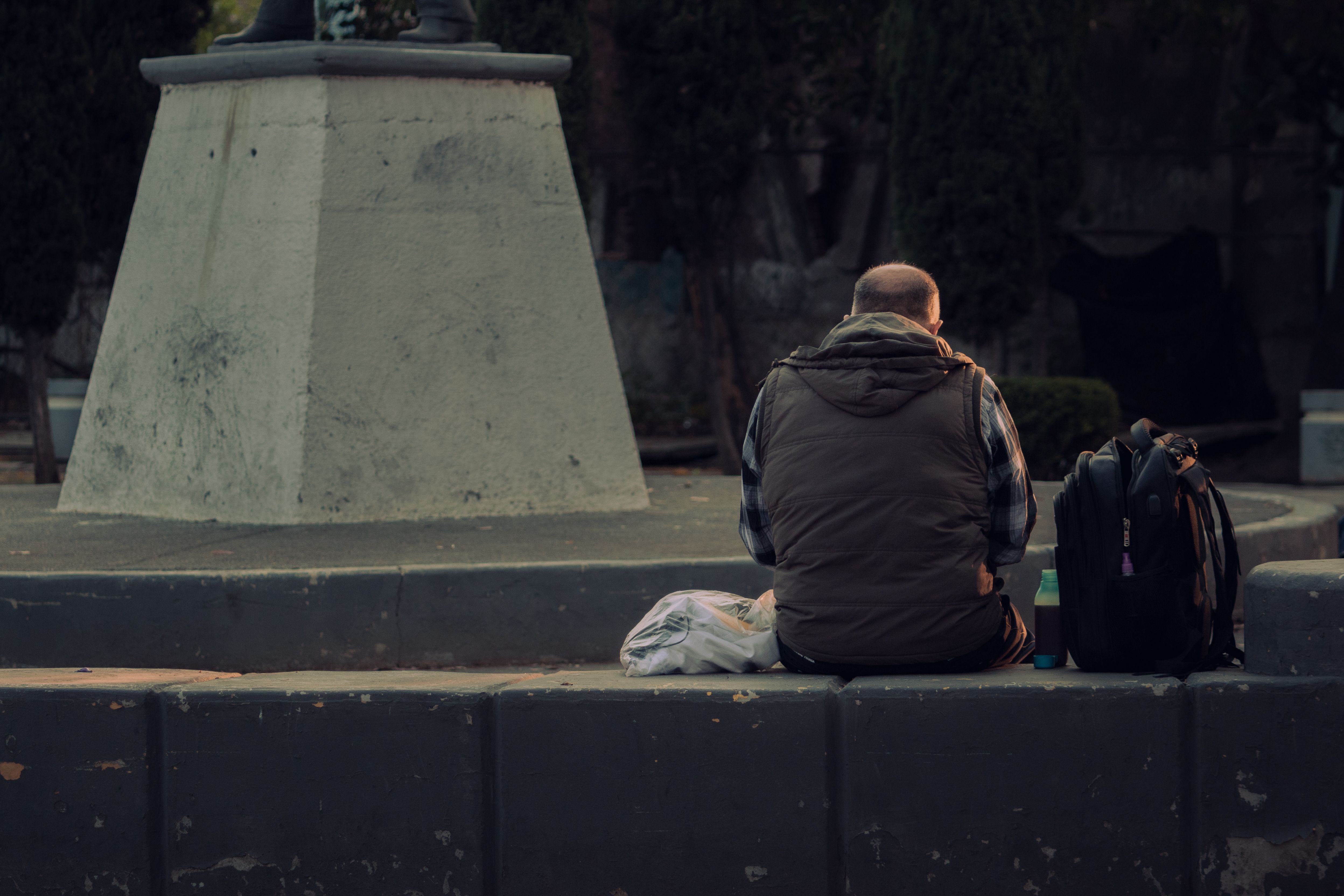 A man sits in Ciudad de México's town square, capturing urban relaxation.