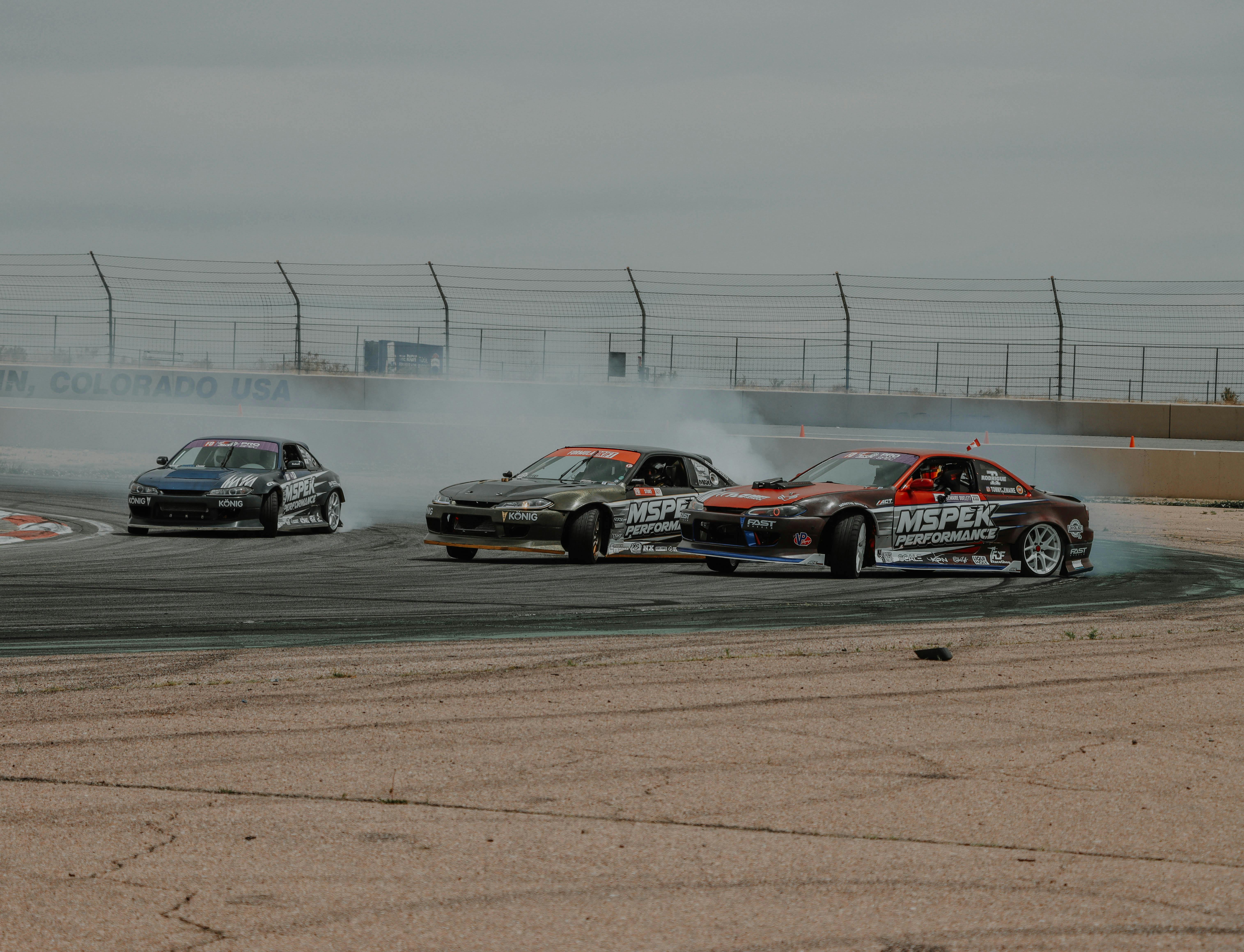 High-speed car drift competition captured on a race track in Colorado, USA. Perfect for motorsport enthusiasts.