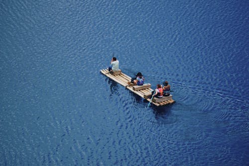 People Riding a Wooden Raft
