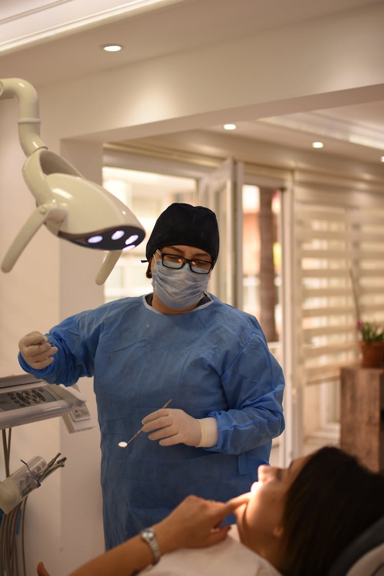 A Dentist Talking To The Patient On The Dental Chair