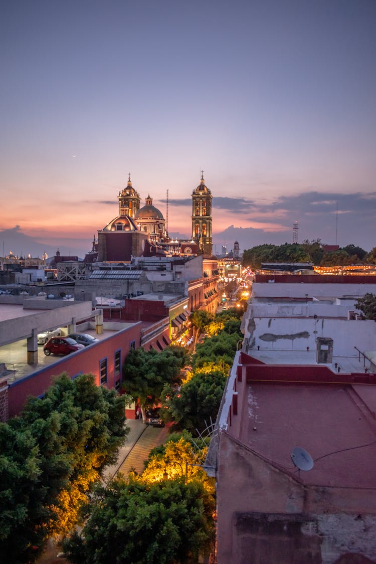 Illuminated Cathedral Overlooking City At Sunset