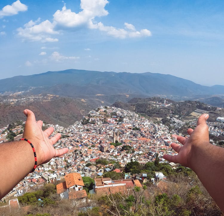 Hands Reaching Towards City