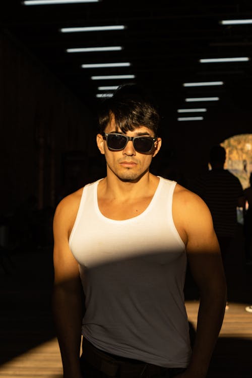 A Man in White Tank Top Wearing Sunglasses