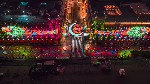 Aerial nighttime shot of brightly illuminated buildings at Zocalo Square, Mexico City, showcasing vibrant decorations.