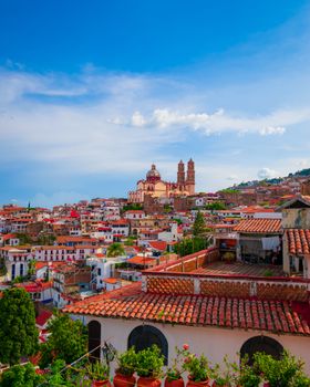 Charming aerial view of Taxco's traditional architecture against a vibrant blue sky.