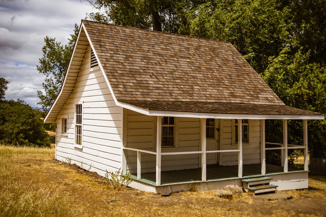 Free Brown and White Wooden House Near Green Trees Stock Photo