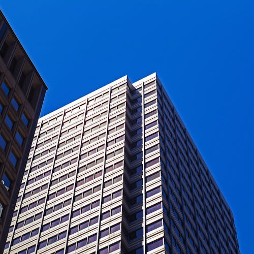 Flachwinkelfoto Des Weißen Betongebäudes Unter Blauem Himmel