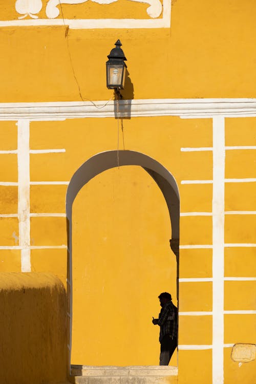 Бесплатное стоковое фото с вертикальный выстрел, верхом, желтая стена