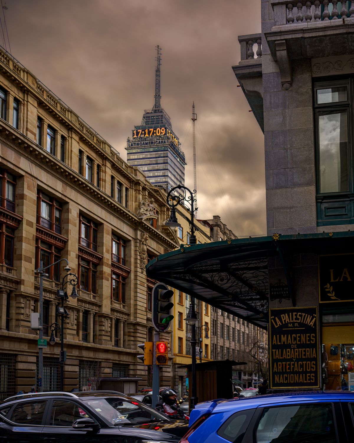 Low angle view of Torre Latinoamericana amid historic buildings in Mexico City with moody sky.