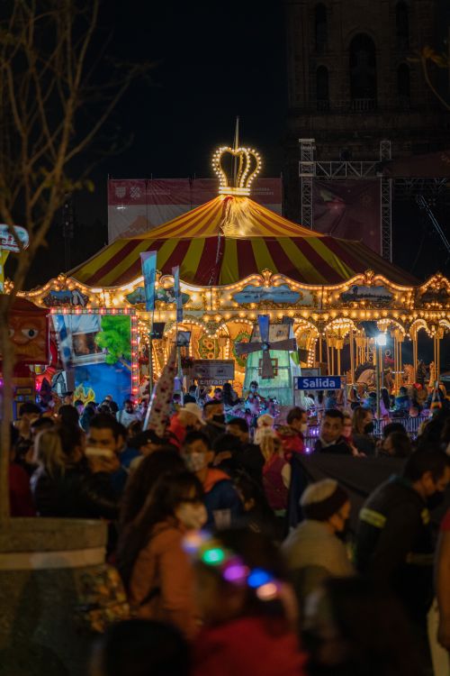 Free A lively crowd enjoys a beautifully lit carousel at a nighttime festival. Stock Photo