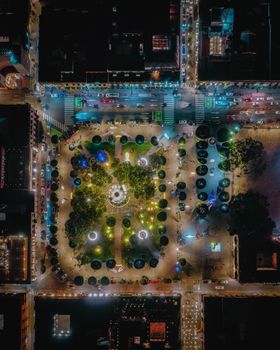 Stunning aerial shot of a well-lit urban park at night with vibrant city lights.