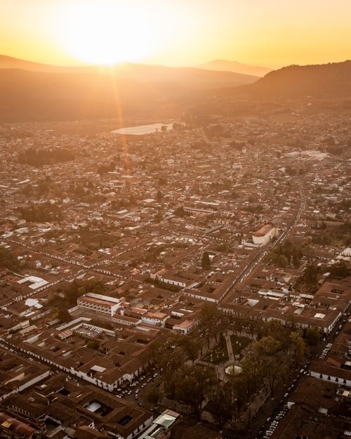 Free A breathtaking aerial view of a sprawling cityscape illuminated by a golden sunset. Stock Photo