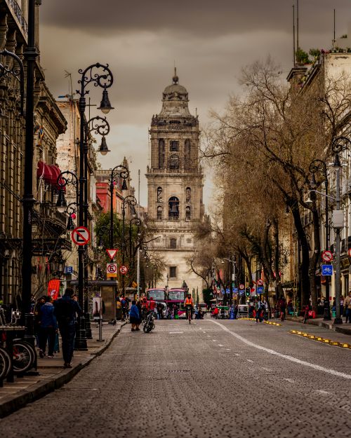 Free A bustling street scene in Mexico City featuring a historic bell tower and vibrant urban life. Stock Photo