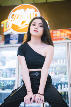 Asian woman in a modern outfit poses confidently inside a Bandung store.