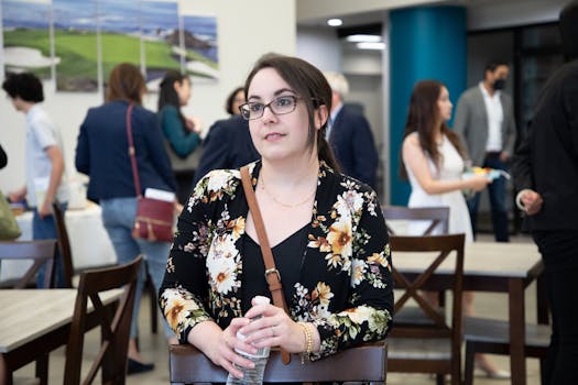 Business woman in floral blazer attentively listening in a meeting.