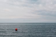 Red Buoy Floating on Body of Water