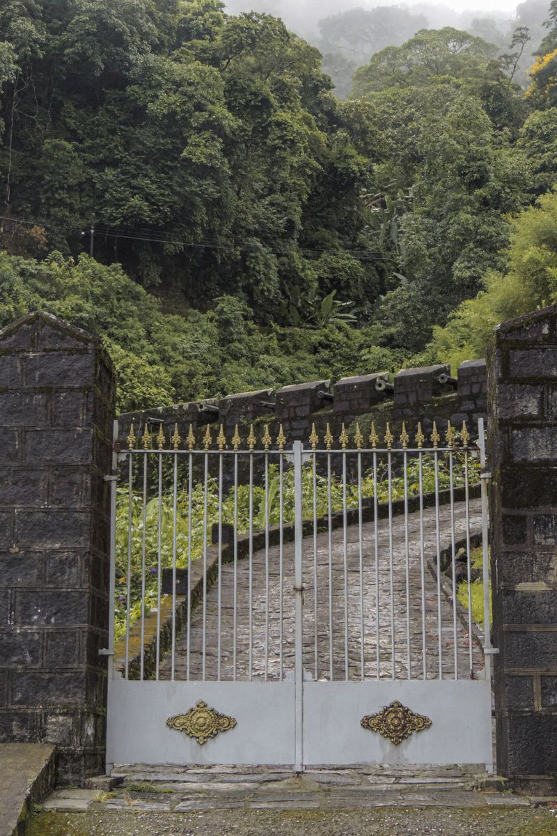 Automated driveway gate between stone pillars