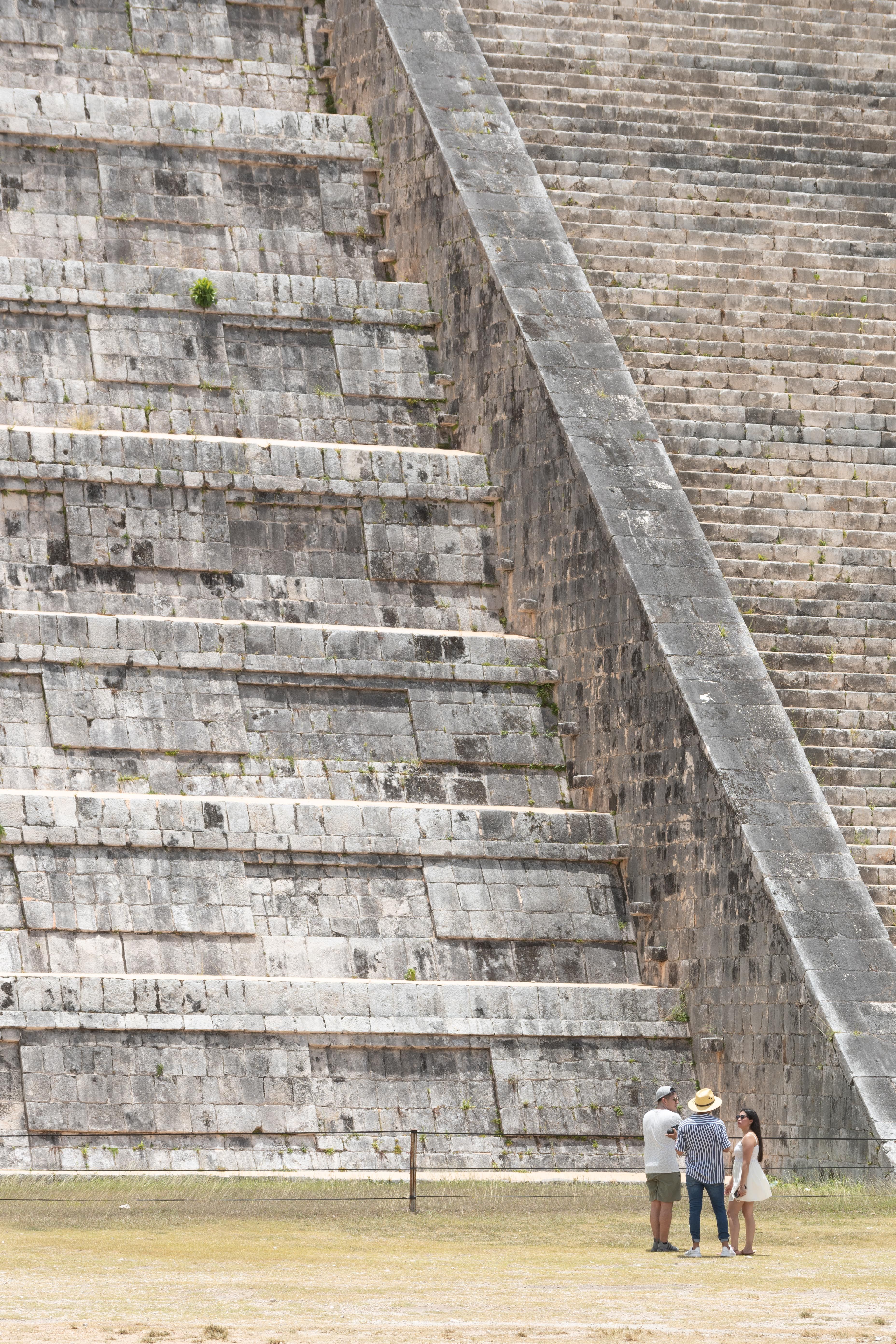 Visitors standing at the foot of the Mayan pyramid steps at Chichén Itzá in the Yucatán