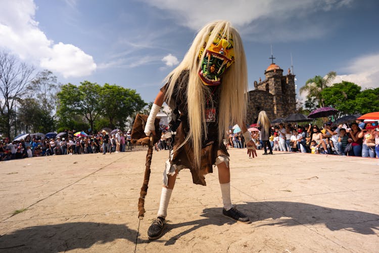 Boy In A Carnival Mask And Crowd In Background