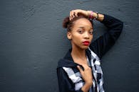 一位时尚的年轻女性在纹理灰色的墙壁前拍摄户外时尚照片